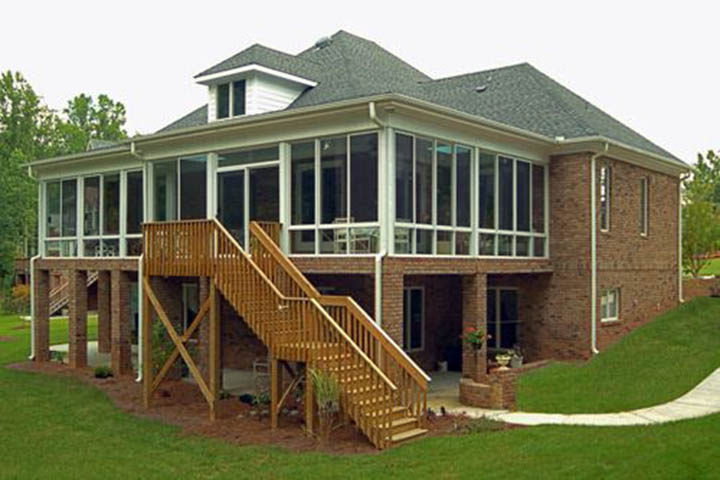 A sunroom extending a 2nd floor or raise house designed with the overall house design in mind with high quality materials that naturally extende the house into the outdoors