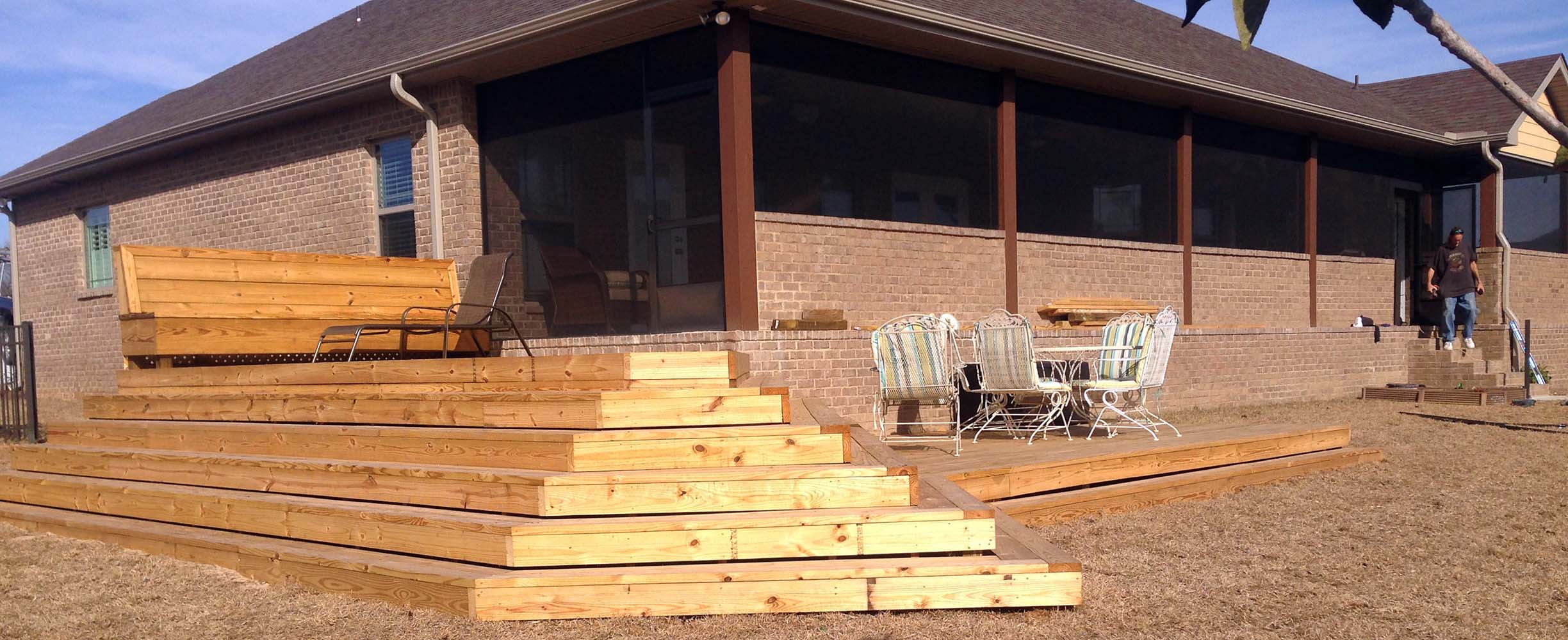 Wooden dech with wooden steps adding functionality to a house while making the garden more beautiful and prectical