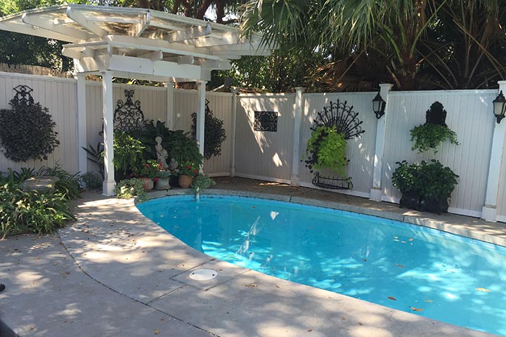 This pergola at the end of a swuimming pool adds dramatic design impact thransfroming the patio and pool environment